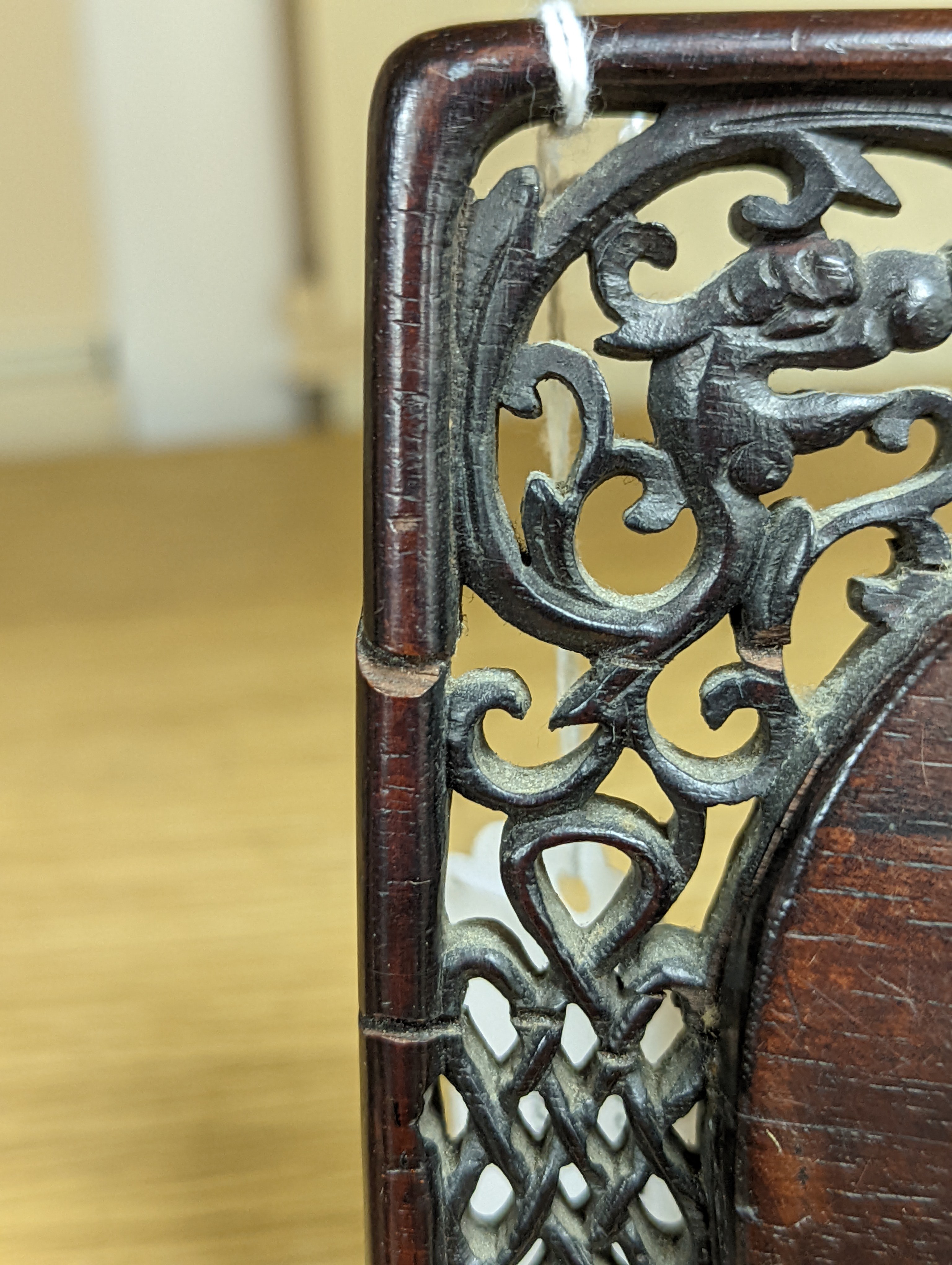 A 19th century Chinese famille rose circular plaque or cover, inset into a wood surround, cracks 15cm sq